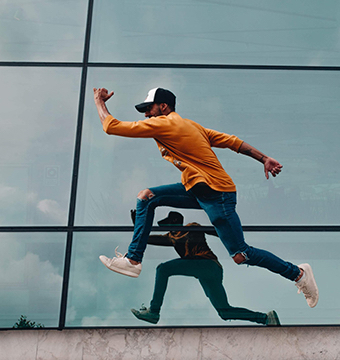 Happy Man Jumping in Front of Building